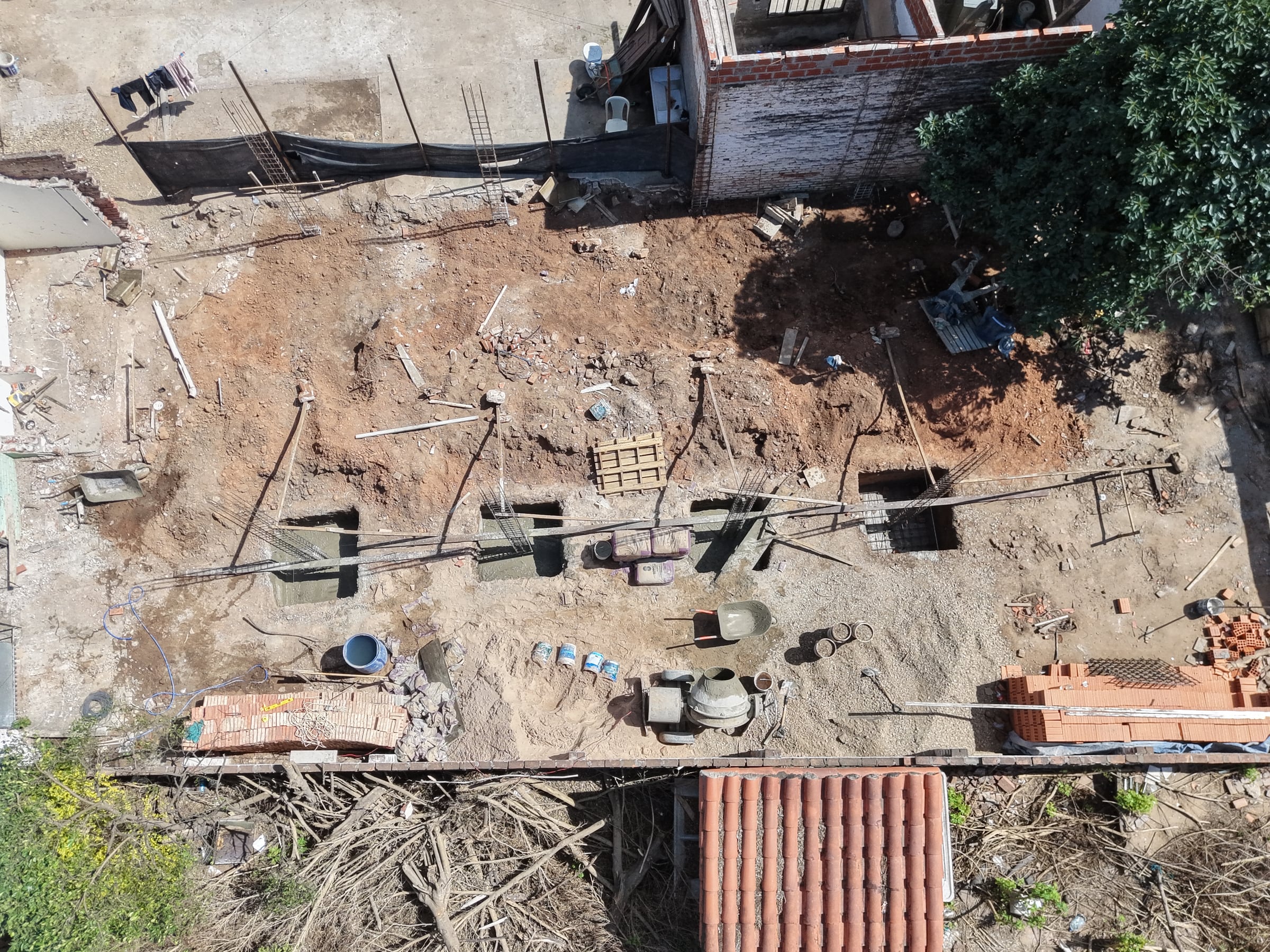 Vista cenital del terreno: la retícula de zapatas y columnas marca la planta de la casa sobre el suelo.