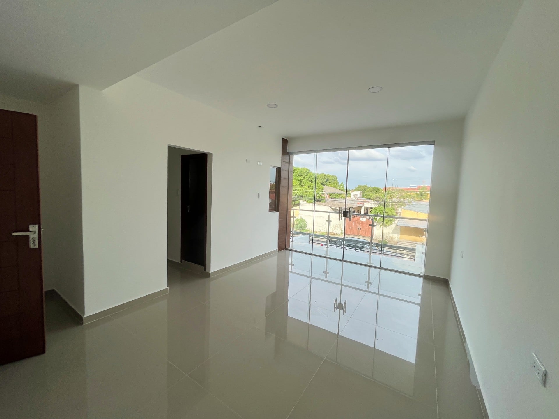 La sala–comedor con ventanal corrido al frente.