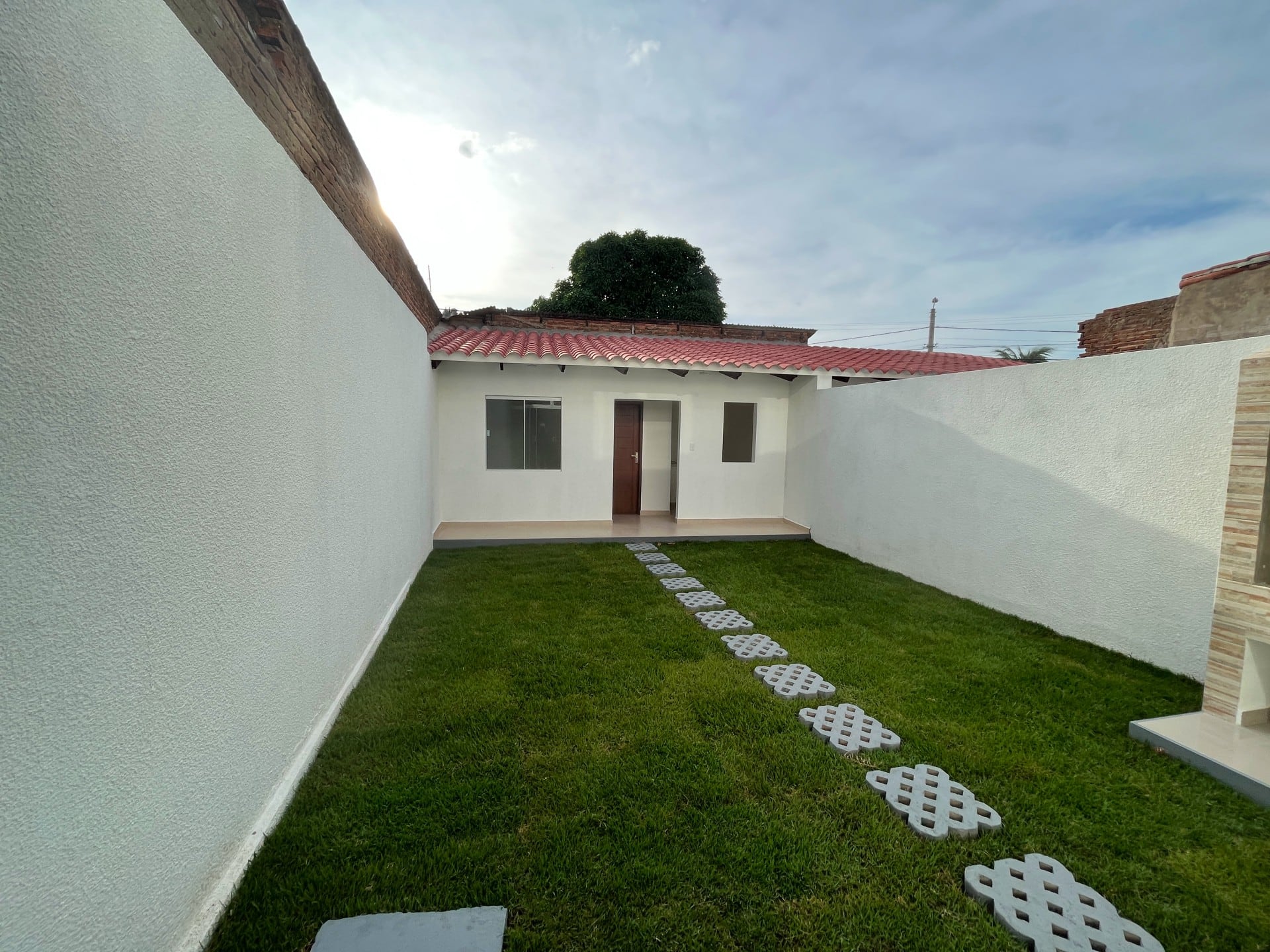 El jardín, con césped y paso de losetas.