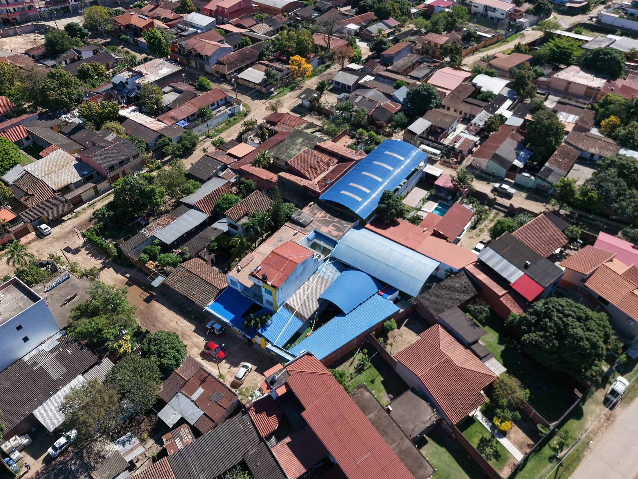 El colegio visto desde arriba dentro de su manzana, rodeado de casas con techo de teja.