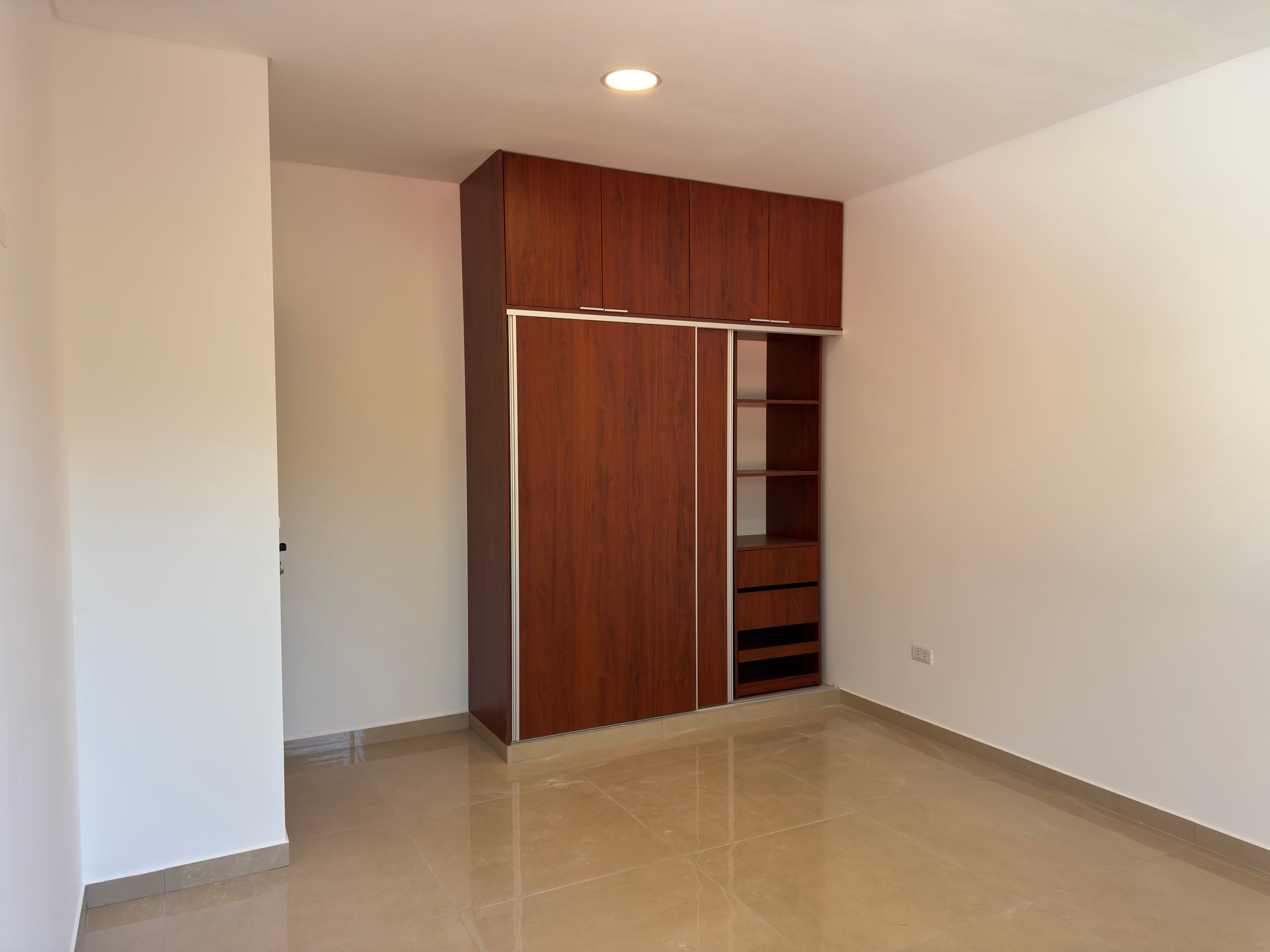 El mueble empotrado en detalle, con estantes y puertas corredizas.