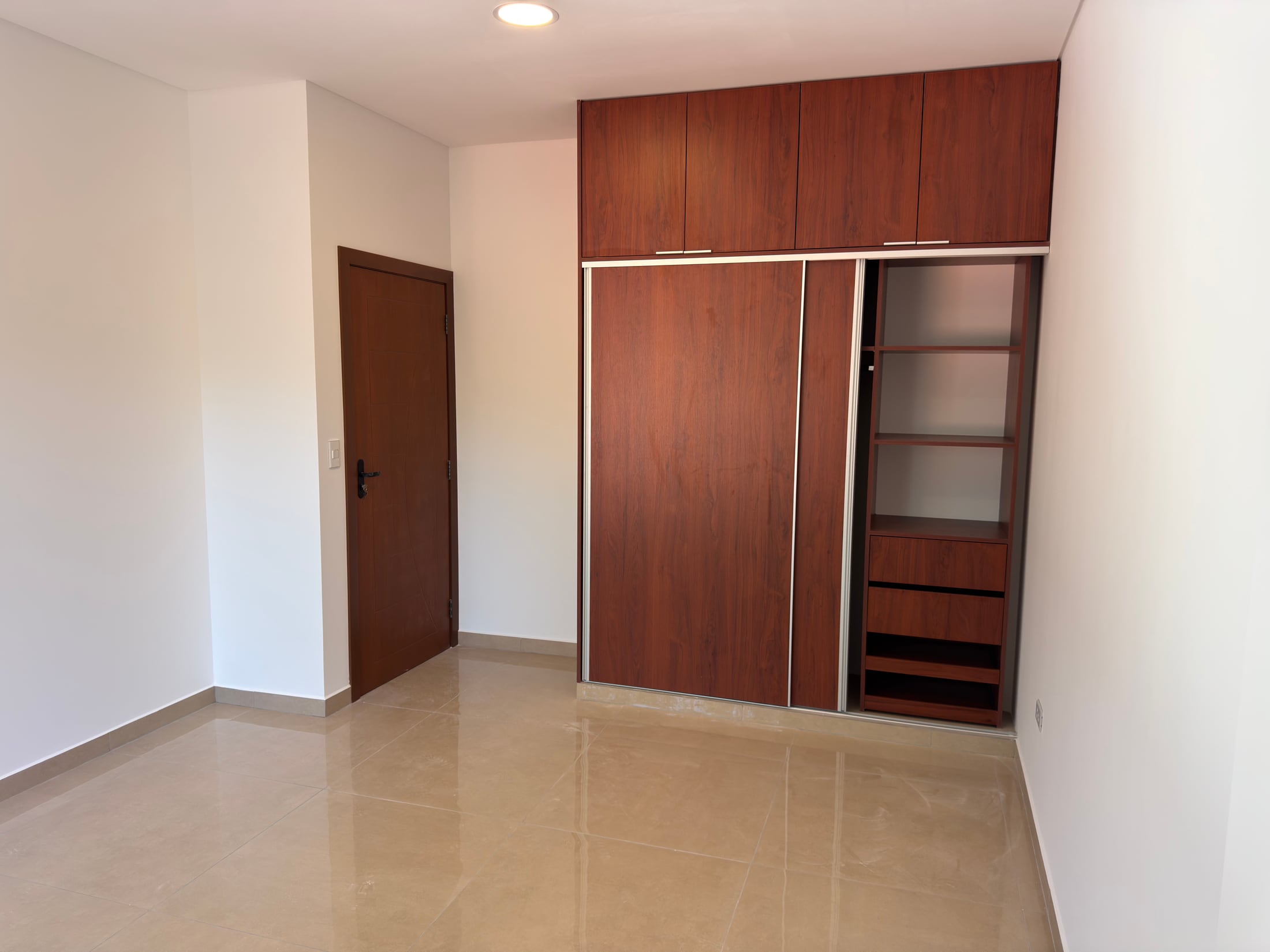 El ropero empotrado abierto, con cajonera y estantes de madera.