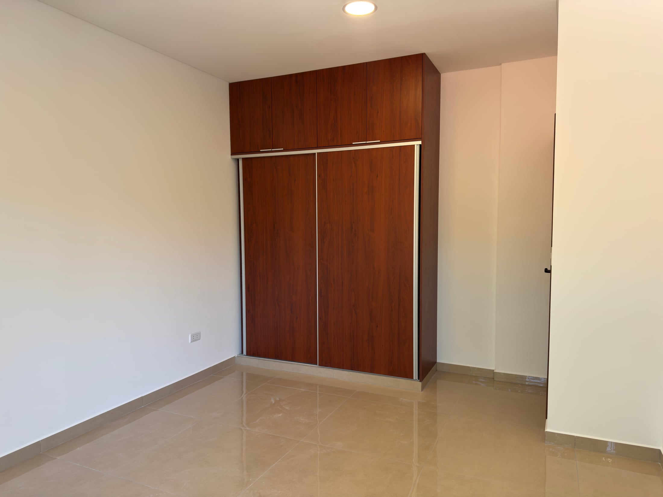Dormitorio con ropero empotrado de madera.