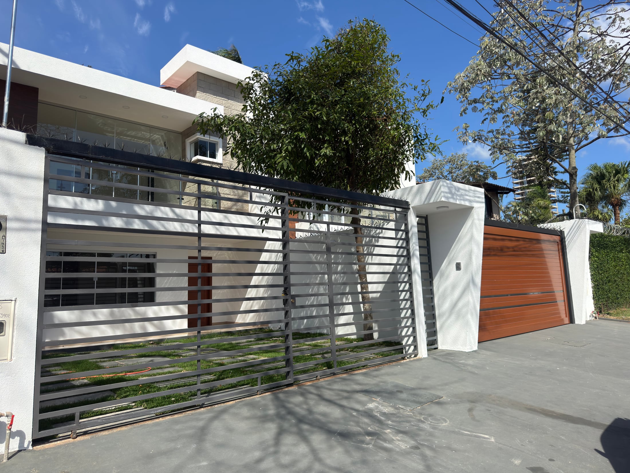 El frente desde la calle: portón de rejas y portón de madera del garaje.