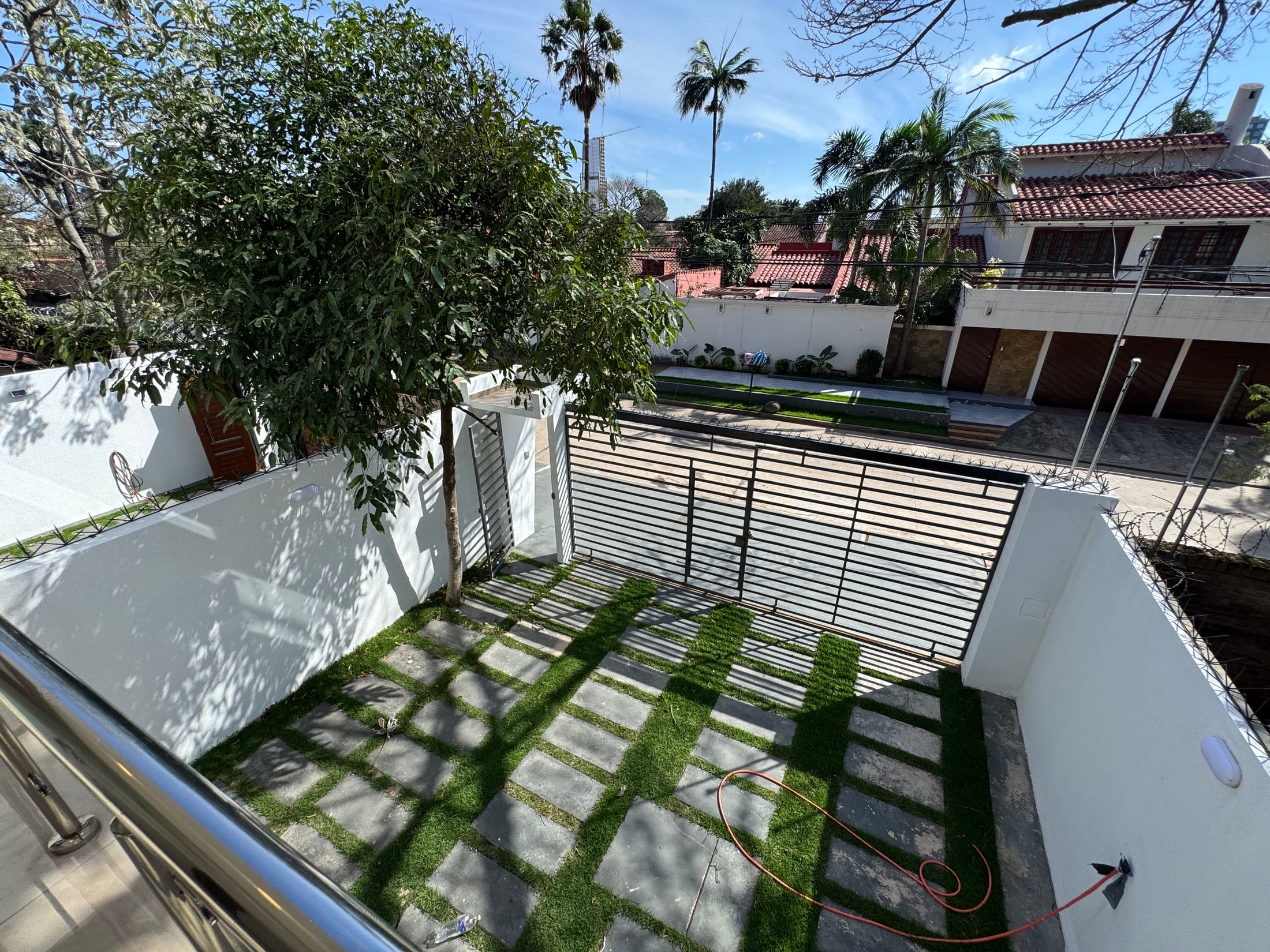 La vista desde el balcón hacia el jardín delantero y la entrada.